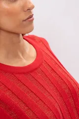 Vestido corto tejido de punto color rojo con hilos dorados, sin mangas y con falda acampanada. Incluye cinturón marrón con flecos.