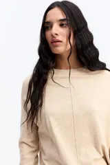 Sweater de punto negro con cuello redondo, manga larga y calce relajado. Presenta una costura vertical central en el frente y puños acanalados.