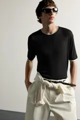 Remera relaxed fit confeccionada en tejido ligero de lyocell, de color negro con cuello redondo, manga corta y acabados en efecto doble combinado a contraste en color blanco.