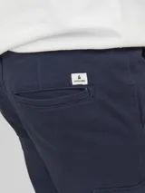 Pantalón cargo de corte slim y tiro medio, color azul marino, con bolsillos laterales tipo cargo con solapa y cierre de cremallera.
