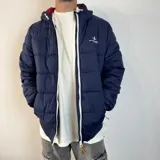 Campera puffer azul marino con cierre frontal blanco, capucha con interior en color bordó y logo bordado en el pecho.