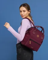 Mochila urbana Cabaia modelo Adventurer, color bordó con detalles en cuero sintético marrón. Cuenta con doble asa superior, bolsillo frontal con cierre y parches con logo de la marca.