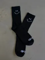 Par de medias largas negras con diseño de carita feliz y texto "BERKAMO" en blanco en la parte superior.