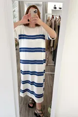 Vestido largo tejido a rayas horizontales azules y beige sobre fondo blanco, con mangas cortas y tajos laterales.