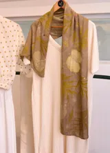 Pañuelo de seda natural color verde romerillo, con impresión botánica de hojas de helecho y malvarrosa.