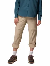 Pantalón Columbia de trekking convertible en bermuda, modelo Leslie Convert Pant Omni-Shade, color beige, con perneras desmontables mediante cremallera, bolsillos laterales y tecnología de protección solar.