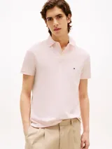 Chomba Tommy Hilfiger de corte regular, color rosa claro, con cuello tipo polo y tapeta de dos botones. Logo bordado en el pecho.