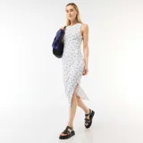 Vestido midi de canalé color beige con estampado floral azul, sin mangas, con cuello redondo y tajo lateral en el dobladillo.
