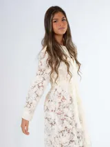 Vestido midi de encaje color crudo, con corte recto, cuello camisero y mangas largas. Incluye cinto de lazo en la cintura y cierre frontal con botones.