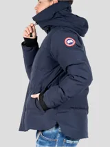 Campera puffer azul marino con capucha, cierre frontal con cremallera y broches, bolsillos laterales con solapa y logo de la marca en el brazo izquierdo.