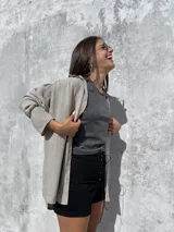 Camisa oversize de textura ligera y efecto nevado, con cuello clásico, cierre frontal de botones y mangas largas con detalle de frunces en los hombros.