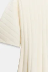 Vestido corto de punto rib color crema, con cuello redondo, manga corta abullonada y falda plisada.