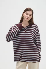 Remera de manga larga con diseño a rayas horizontales, cuello tipo polo con cierre de botones y corte holgado.