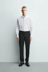 Camisa slim fit de algodón en color blanco, con cuello smoking y manga larga con puño doble abotonado.