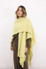 Ruana tejida en lana merino color ladrillo, con textura de punto grueso.