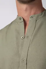 Camisa de manga larga confeccionada en lino, con cuello mao y cierre frontal de botones. Presenta un corte relajado y diseño minimalista.