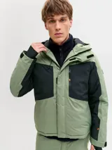 Campera técnica impermeable y cortaviento con capucha ajustable, diseñada para condiciones de frío, viento y lluvia. Confeccionada en tejido resistente, cuenta con cierre frontal con tapeta, bolsillos con cierre, ventilación bajo los brazos y ajustes en puños para evitar la entrada de nieve.