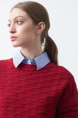 Sweater de punto tramado color azul marino, con cuello redondo, mangas abullonadas y puños elastizados.