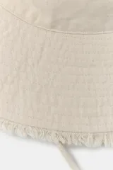 Gorro tipo bucket de algodón color beige, con ala ancha con acabado deshilachado y pespuntes, y cordón ajustable con stopper.