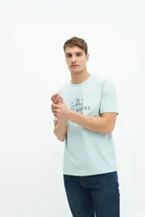 Remera celeste de manga corta con estampado de peces y texto en el frente.