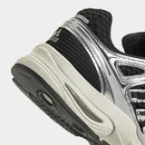 Championes Adidas Adistar Control 5 de running, con diseño retro de los años 2000. Combinan base de malla negra con superposiciones metálicas plateadas y entresuela en tono blanquecino.