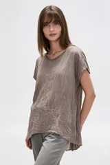 Blusa holgada de algodón color verde oscuro, de manga corta y cuello redondo, con diseño asimétrico más largo en la parte trasera y costuras decorativas.