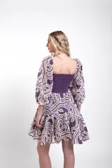 Vestido corto de encaje celeste y crudo, con cuerpo superior fruncido y elastizado, escote cuadrado, mangas abullonadas y falda con volados.