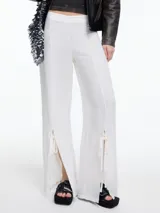 Pantalón blanco de lino y viscosa, de corte ancho con tajos laterales en la botamanga y lazos ajustables.