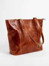 Cartera tote de cuero natural color beige, con doble asa larga para hombro y cierre superior con broche.