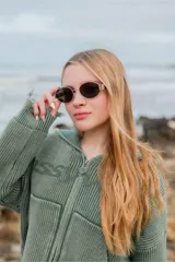 Lentes de sol con armazón metálico dorado y lentes oscuros de diseño ovalado.