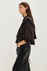 Camisa de algodón con diseño de encaje bordado, cuello mao, cierre frontal de botones y mangas largas con puños con volados.