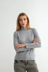 Polera de tejido de punto fino color bordó, con cuello alto y mangas largas.
