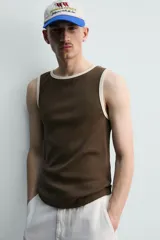Camiseta sin mangas slim fit color crema, confeccionada en tejido de algodón elástico, con cuello redondo y ribetes en contraste color beige.