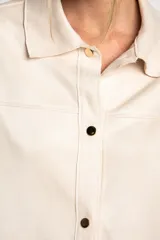 Camisa tipo sobrecamisa oversize color crudo, confeccionada en tejido de gamuza vegana con cierre frontal de botones metálicos y cuello clásico.