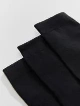 Kit de tres pares de medias unisex de caño medio, confeccionadas en tejido suave y elástico de color blanco, con el logo de la marca estampado en la planta del pie.