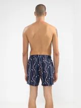 Short de baño azul marino con estampado de cadenas doradas, plateadas y rosadas.