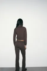 Pantalón de felpa marrón, de tiro alto con cintura elástica y diseño flare acampanado en las pantorrillas.