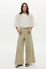 Jean estilo wide leg de tiro alto y pierna ancha, color verde claro, con costuras frontales marcadas y bolsillos laterales.