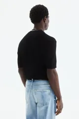 Remera de punto suave color negro, de corte slim fit, con cuello redondo acanalado y mangas cortas.