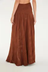 Falda larga de punto color marrón, de tiro alto y diseño fluido con una abertura frontal y tejido texturizado con motivos de hojas.