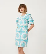 Vestido corto blanco con estampado de flores y corazones en color celeste, de corte recto, con mangas abullonadas y lazo en la espalda.