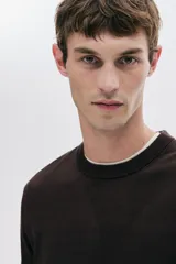 Buzo de punto fino color marrón oscuro, con cuello redondo y remates acanalados en cuello, puños y bajo. Corte estándar.