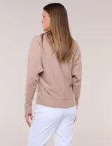 Buzo tejido fino de Allie Rose en color beige, con escote en V, costura central expuesta, mangas largas con puño ajustado y diseño relajado.