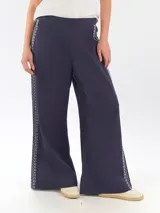 Pantalón ancho de lino color azul marino, de tiro alto, con bordado decorativo en color blanco en los laterales.