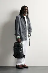 Mochila de piel negra de la colección especial Aaron Levine x Zara, con compartimento principal con solapa y hebilla, bolsillos exteriores en los laterales y asas ajustables.