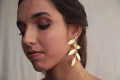 Aros colgantes con forma de rama con hojas doradas.