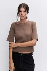 Remera de algodón color marrón, con cuello redondo y mangas cortas, de corte recto y largo a la cintura.