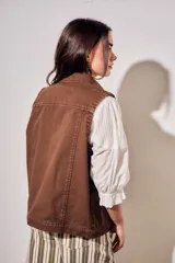 Chaleco oversize de algodón color marrón con efecto lavado, cuello solapa y cierre frontal con botones metálicos. Cuenta con bolsillos frontales diagonales.