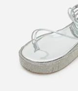Sandalias plateadas con plataforma flatform cubierta de strass, tiras finas y lazo para atar al tobillo.