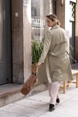 Trench largo de gamuza en color beige, con solapas amplias, diseño abierto y corte recto.